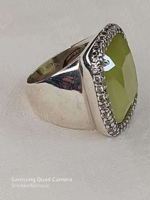 Sterling silver ladies ring with very large green stone surrounded with cubic zirconia Size: M.5