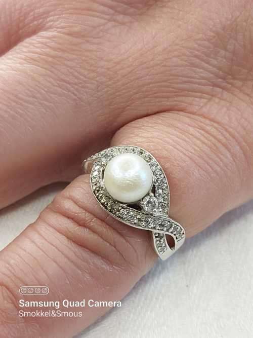 Sterling silver ladies ring with genuine pearl surrounded with cubic zirconia Size: O.5