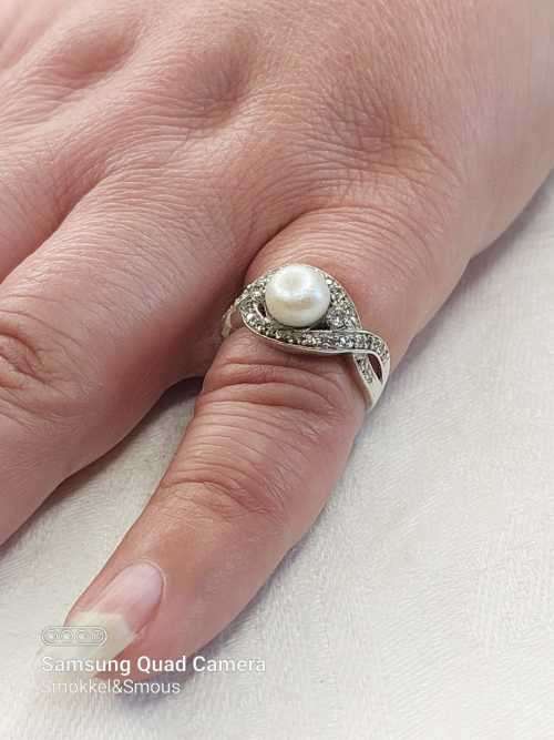 Sterling silver ladies ring with genuine pearl surrounded with cubic zirconia Size: O.5