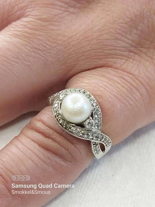 Sterling silver ladies ring with genuine pearl surrounded with cubic zirconia Size: O.5