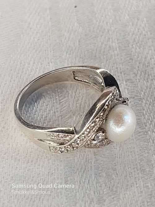 Sterling silver ladies ring with genuine pearl surrounded with cubic zirconia Size: O.5