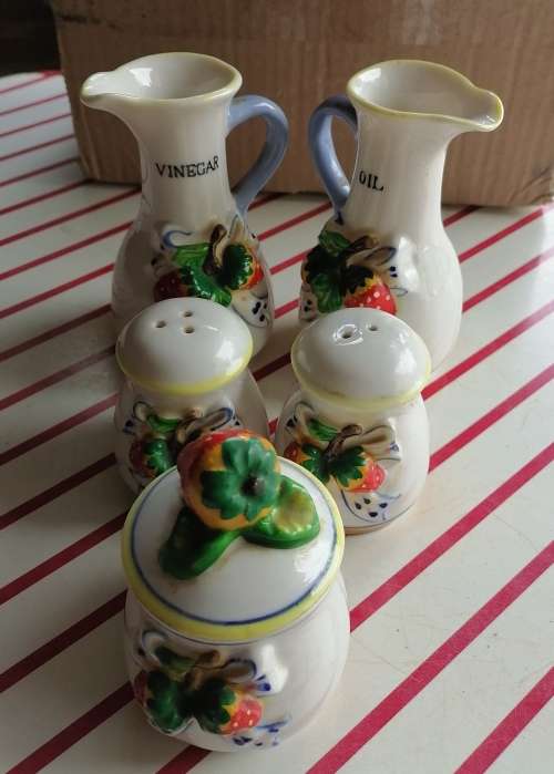 Small set containing oil and vinegar, salt and pepper and a small pot.