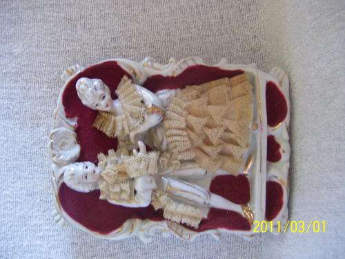 Old wall hanging with felt and lace on porcelain