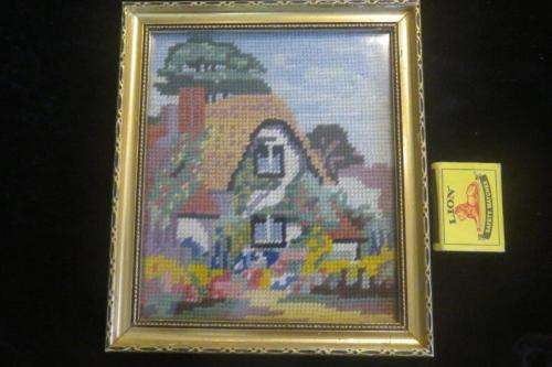 Small tapestry of a cottage - behind glass