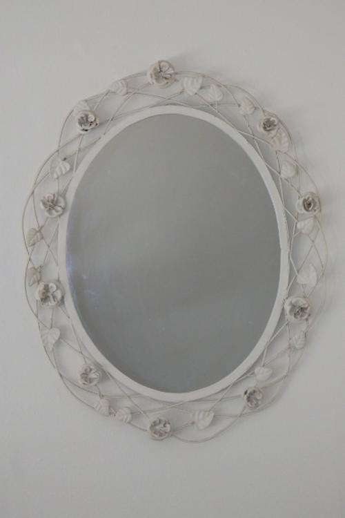A BEAUTIFUL OFF-WHITE OVAL (METAL) MIRROR WITH HANDMADE FLORAL DETAILING AROUND THE MIRROR