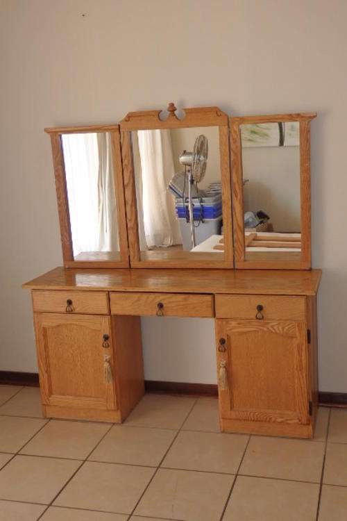 A STUNNING OAK THREE MIRROR DRESSING TABLE WITH THREE DRAWERS AND TWO CABINETS