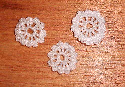 A set of three tiny doilys,white.