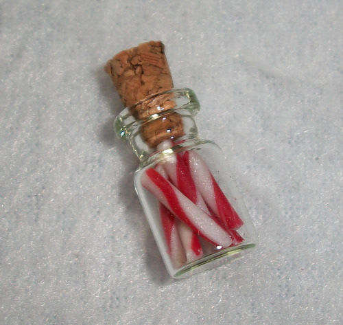 Miniature glass jar filled with candysticks.