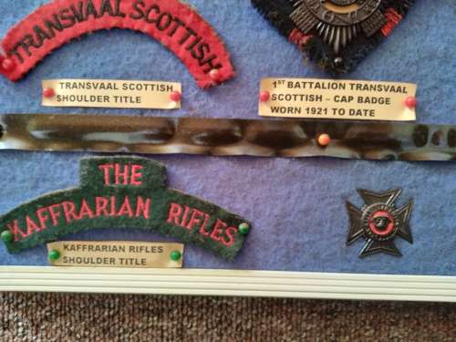 Display of South African Traditional Regiments cap/beret badges, shoulder titles and collar badges.