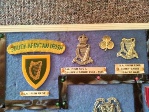 Display of South African Traditional Regiments cap/beret badges, shoulder titles and collar badges.