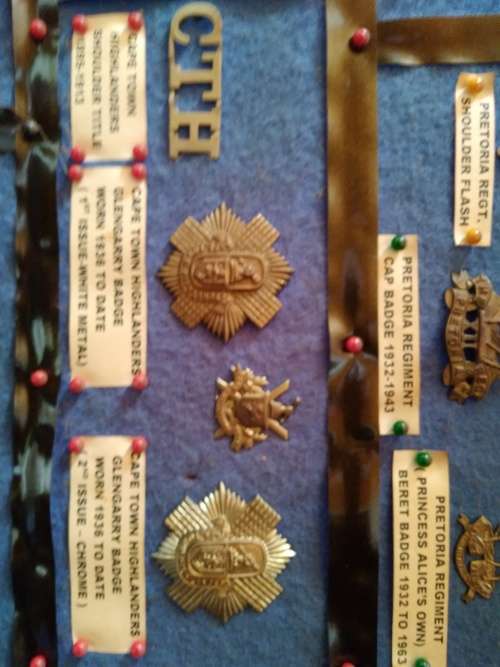 Display of South African Traditional Regiments cap/beret badges, shoulder titles and collar badges.