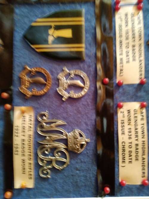 Display of South African Traditional Regiments cap/beret badges, shoulder titles and collar badges.