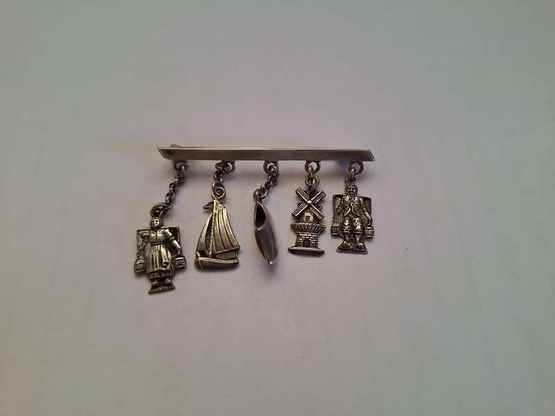Stunning silver brooch adorned with trinkets