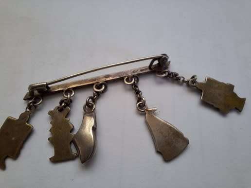 Stunning silver brooch adorned with trinkets