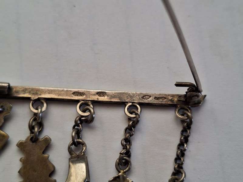 Stunning silver brooch adorned with trinkets
