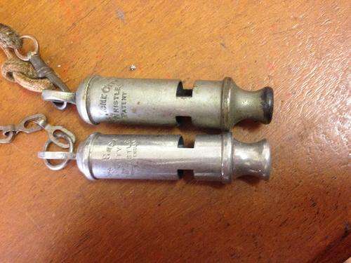 A pair of Acme police whistles