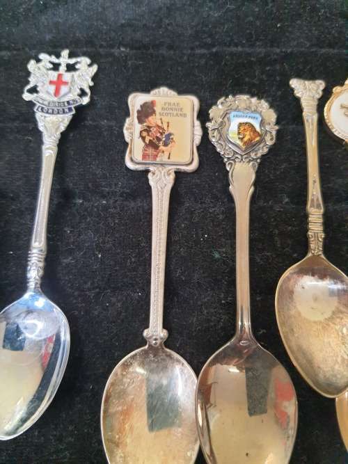 A COLLECTION OF 12 VINTAGE SOUVENIR SPOONS SOLD AS IS