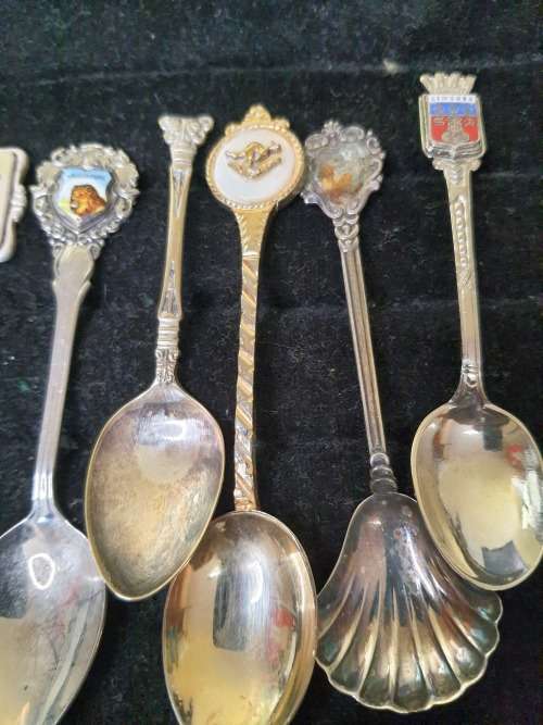 A COLLECTION OF 12 VINTAGE SOUVENIR SPOONS SOLD AS IS