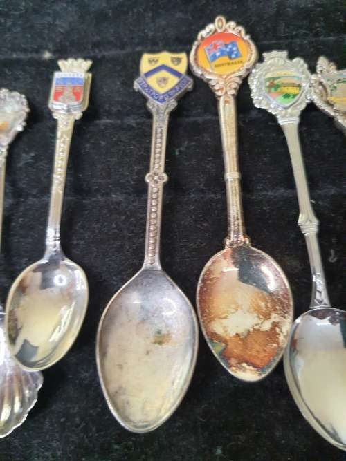 A COLLECTION OF 12 VINTAGE SOUVENIR SPOONS SOLD AS IS