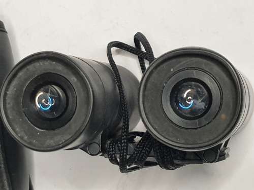 A USED TASCO POCKET BINOCUARS WITH ITS ORIGINAL COVER SOLD AS IS