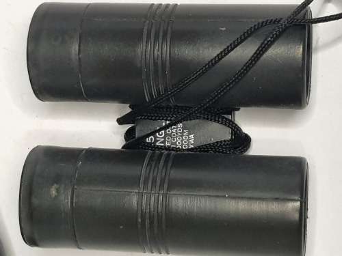 A USED TASCO POCKET BINOCUARS WITH ITS ORIGINAL COVER SOLD AS IS