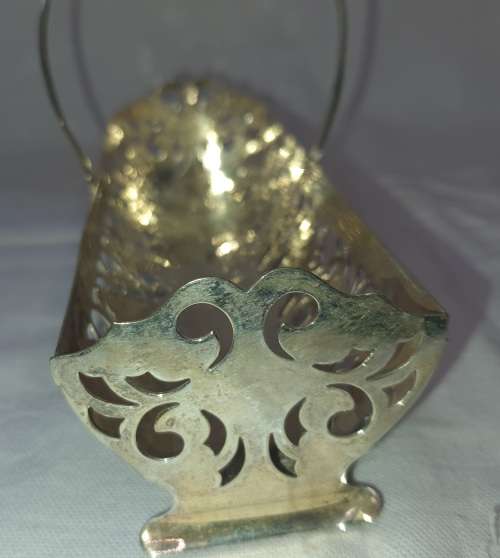 A VINTAGE SILVER PLATED BISCUITE BASKET SOLD AS IS