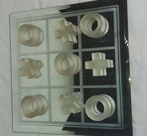 A GLASS CRYSTAL 10 PIECE TIC TAC TOE SET WITH A MIRRORED BOARD IN GOOD CONDITION SOLD AS IS