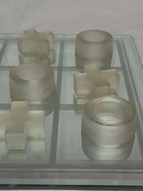 A GLASS CRYSTAL 10 PIECE TIC TAC TOE SET WITH A MIRRORED BOARD IN GOOD CONDITION SOLD AS IS