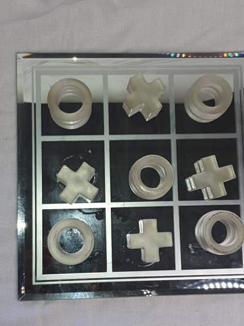 A GLASS CRYSTAL 10 PIECE TIC TAC TOE SET WITH A MIRRORED BOARD IN GOOD CONDITION SOLD AS IS