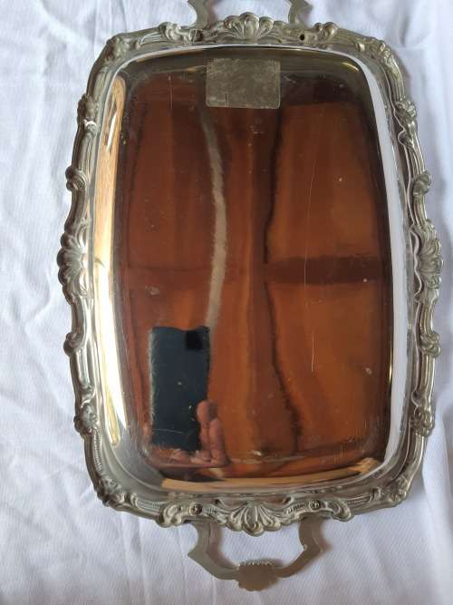 A VINTAGE SILVER PLATED SERVING TRAY WITH ORNATE HANDLES SOLD AS IS