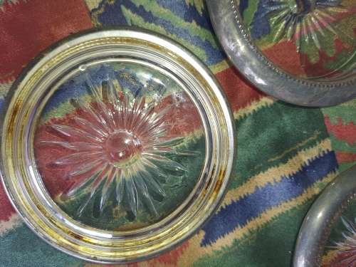 A vintage set of 6 cut glass coasters with silver plated brims sold as is
