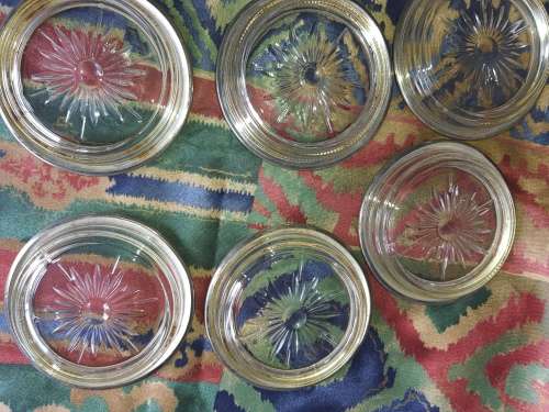 A vintage set of 6 cut glass coasters with silver plated brims sold as is