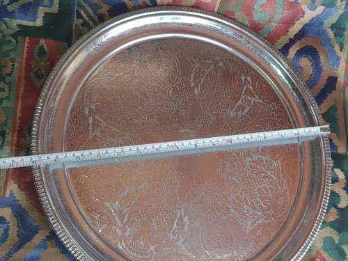 A VINTAGE ROUND SILVER PLATED SERVING TRAY SOLD AS IS