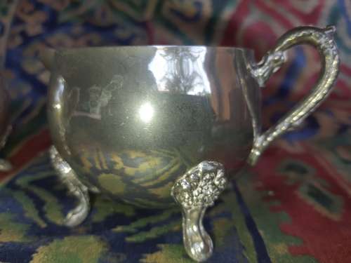 A VINTAGE PAIR OF SILVERPLATED UTENSILS , A CREAMER AND A SUGAR BOWL