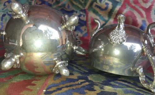 A VINTAGE PAIR OF SILVERPLATED UTENSILS , A CREAMER AND A SUGAR BOWL