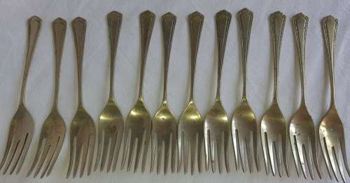 A DOZEN ANTIQUE DESERT FORKS SOLD AS IS