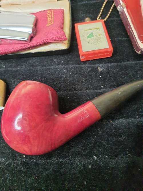 AN ANTIQUE COLLECTION SMOKER COLLECTORS ITEMS RARE LIGHTERS AND A PIPE SOLD AS IS