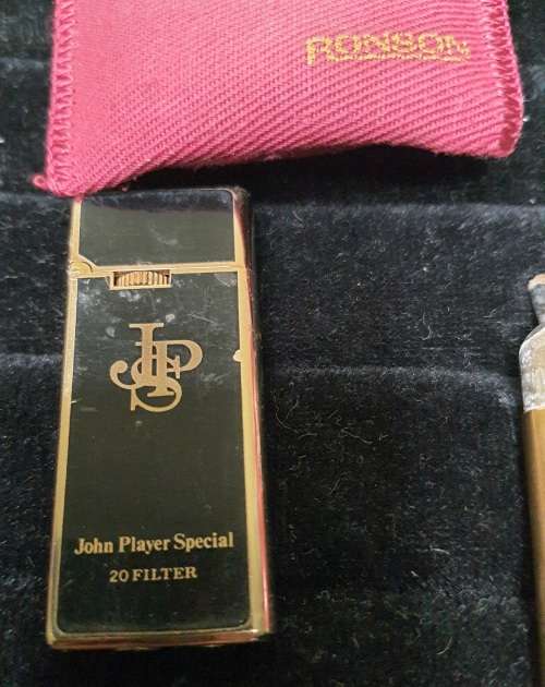AN ANTIQUE COLLECTION SMOKER COLLECTORS ITEMS RARE LIGHTERS AND A PIPE SOLD AS IS