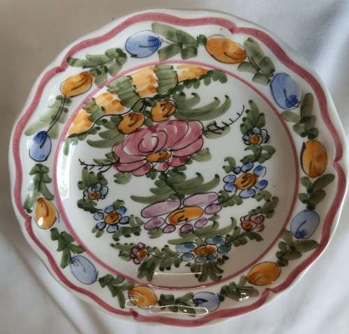 A HAND PAINTED FLORAL DESIGN PORCELAIN WALL PLAUE BY BA SKYROS SOLD AS IS