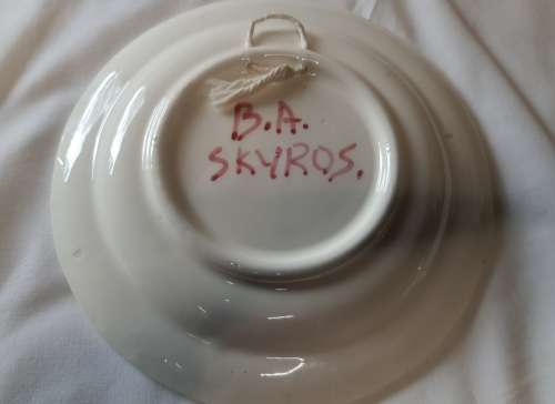 A HAND PAINTED FLORAL DESIGN PORCELAIN WALL PLAUE BY BA SKYROS SOLD AS IS