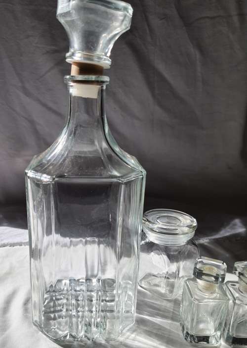 A COLLECTION OF VINTAGE STORAGE BOTTLES SOLD AS IS