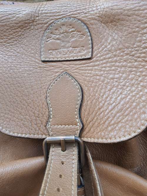 A BROWN LEATHER NAPSACK SOLD AS IS