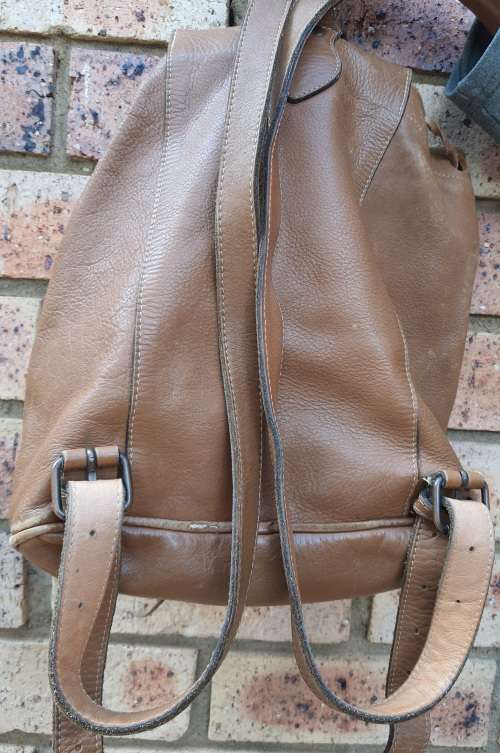 A BROWN LEATHER NAPSACK SOLD AS IS