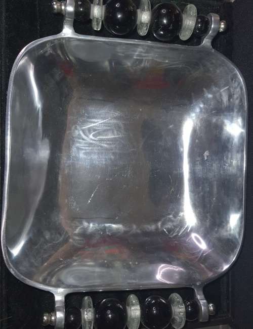 AN ALLUMINIUM ALLOY SERVING BOWL WITH ORNATE HANDLES