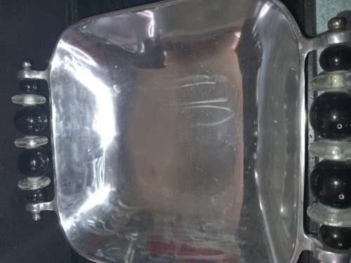 AN ALLUMINIUM ALLOY SERVING BOWL WITH ORNATE HANDLES