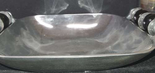 AN ALLUMINIUM ALLOY SERVING BOWL WITH ORNATE HANDLES