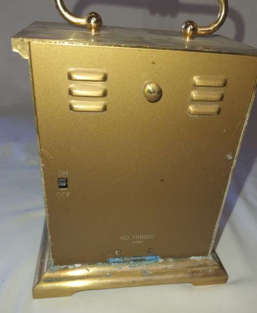 A BRONZE RYTHM TRANSSISTER ALARM CLOCK SOLD AS IS