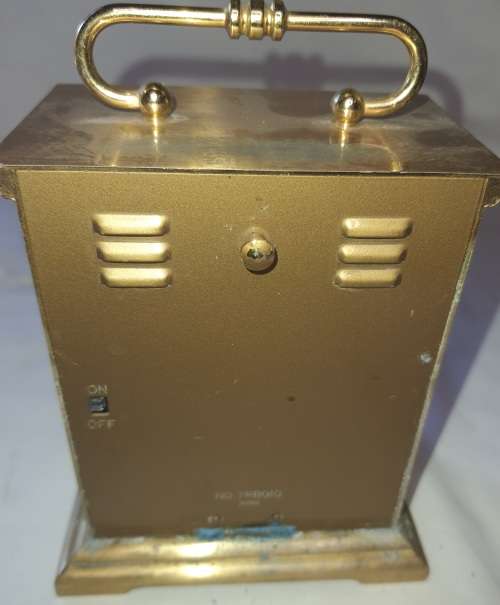 A BRONZE RYTHM TRANSSISTER ALARM CLOCK SOLD AS IS