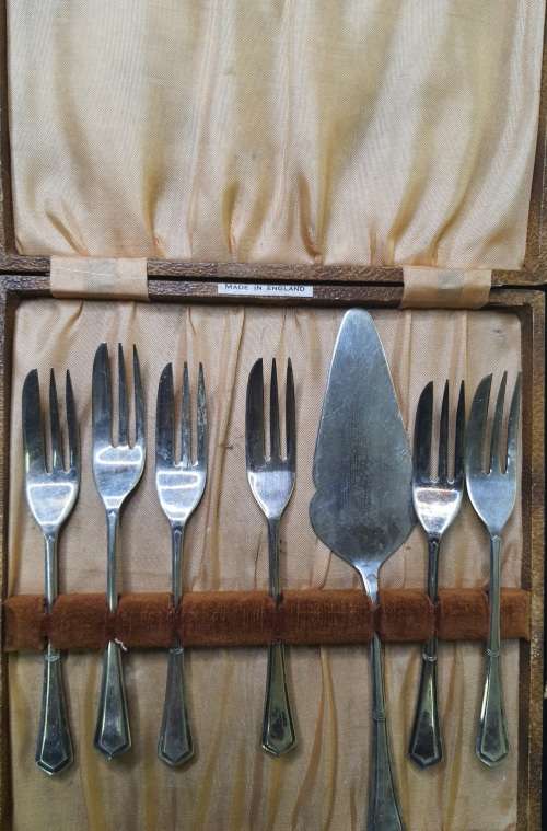 AN ANTIQUE DESERT CAKE SERVING SET IN ITS ORIGINAL BROWM CASE SOLD AS IS