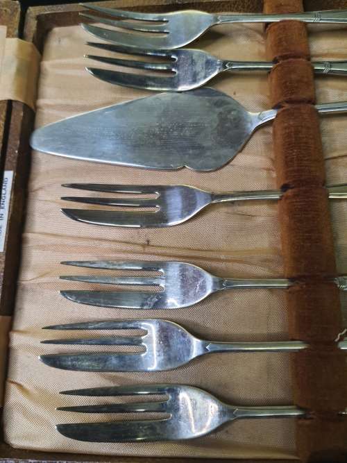 AN ANTIQUE DESERT CAKE SERVING SET IN ITS ORIGINAL BROWM CASE SOLD AS IS
